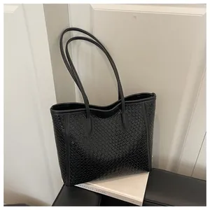Détail de la texture en cuir tressé noir sur un sac fourre-tout élégant pour femmes