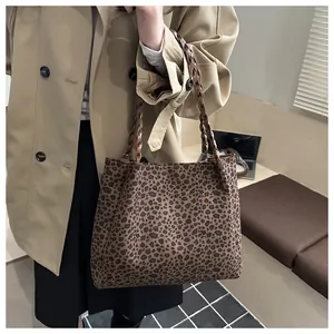 Detailed view of leopard print tote bag with brown woven handles on a trench coat model