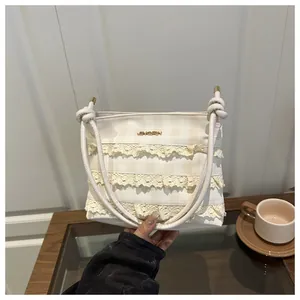 Detailed view of layered lace trim and plaid pattern on this elegant bucket bag