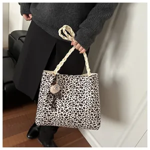 Detail of leopard print tote bag with braided handles and plush ice cream charm