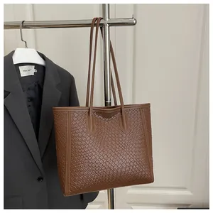 Détail de la texture tissée marron et des fines bandoulières d'un grand sac cabas fourre-tout