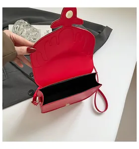 Détail du sac rouge montrant le fermoir magnétique doré et l'espace intérieur