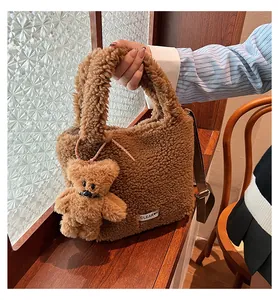 Close-up of brown fuzzy plush bucket bag with cute teddy bear charm on wooden window sill