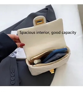 Dettaglio dell'ampio scomparto interno della borsa a tracolla trapuntata beige