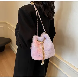 Detail of pink and purple plush bucket bag with golden chain and pearl drawstring