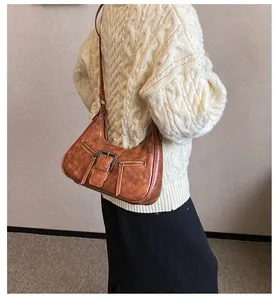 Détail du sac hobo vintage marron avec double fermeture éclair et boucle sur le modèle
