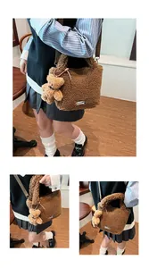 Detail view of brown fuzzy teddy bucket bag with bear pendant and adjustable strap