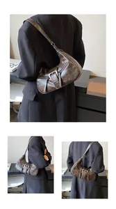 Détail du sac hobo marron vintage avec boucle ardillon et fermetures éclair métalliques