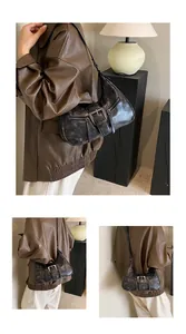 Détail du sac demi-lune rétro montrant la texture du cuir et la boucle métallique
