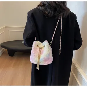 Detail of plush rainbow bucket bag featuring gold chain drawstring and pearl charms