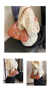 Détail du sac demi-lune vintage marron avec boucle en métal et texture cuir