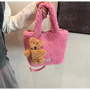 Detail of pink faux fur bucket bag featuring a cute brown plush bear charm and brand tag