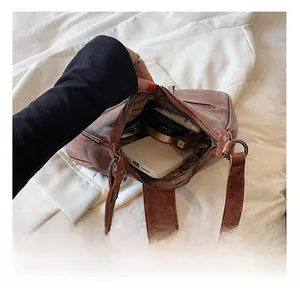 Détails de l'intérieur du sac à bandoulière en cuir marron avec rangement quotidien