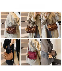 Modèle portant des sacs hobo en motif léopard et daim avec pendentifs en peluche