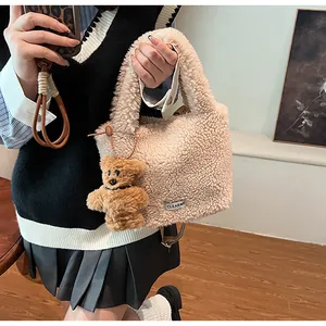 Detail of cream plush bucket bag featuring soft faux fur texture and cute bear pendant