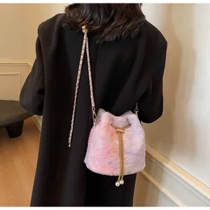 Detail of gradient pink plush bucket bag with sequins and pearl drawstring on model