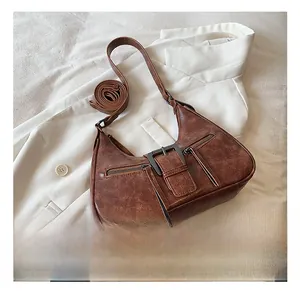 Détail du sac sous l'aisselle vintage marron foncé avec texture cuir et deux sangle