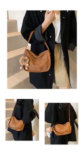 Vues détaillées d'un sac hobo en daim marron avec breloque peluche et logo mode