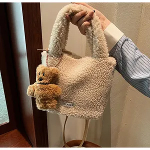 Detail of beige faux fur bucket bag featuring a clear brand tag and cute bear charm