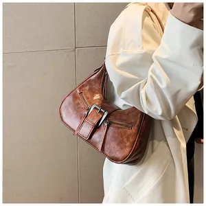 Gros plan d'un sac porté épaule marron vintage avec cuir texturé et boucles métalliques