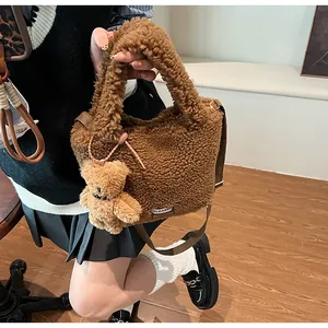 Detailed shot of coffee brown fluffy bucket bag with cute bear charm and shoulder strap