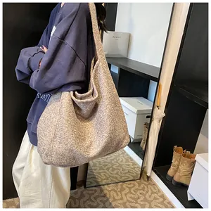 Chic grey textured hobo shoulder bag shown worn by model in a modern interior setting
