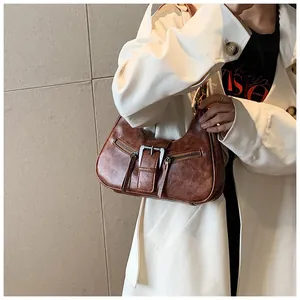 Détail du sac vintage marron en similicuir texturé cire avec des boucles métalliques