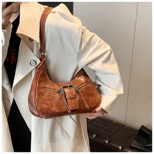 Détail du sac hobo marron vintage montrant le cuir ciré plissé et la boucle métallique