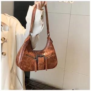 Détail du sac demi-lune marron rétro avec fermetures éclair et boucles en métal