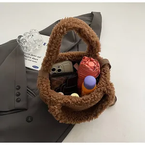 Internal storage detail of brown plush bucket bag showing phone, wallet and umbrella