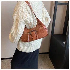 Détail d'un sac demi-lune marron rétro avec boucle en métal et poches zippées