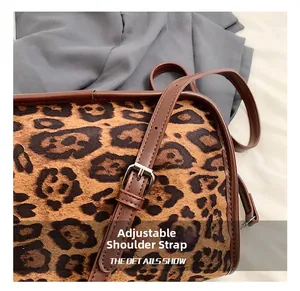 Détail de la bandoulière réglable en simili cuir et boucle sur sac à imprimé léopard
