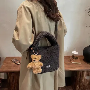 Chic dark gray fuzzy bucket bag with cute bear charm for autumn winter fashion look
