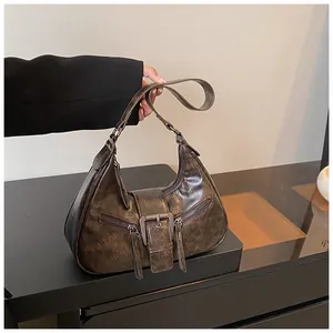 Vue détaillée du sac croissant marron vintage avec cuir ciré rétro et boucle métallique