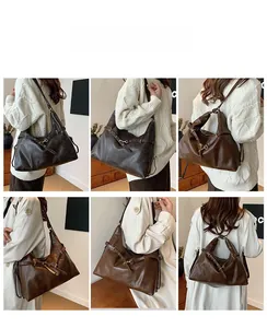 Detail view of large vintage brown oil-wax leather shoulder bag with side buckle straps