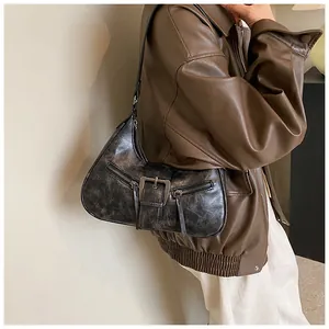 Détail de la texture en cuir vieilli et boucle métallique sur le sac croissant vintage