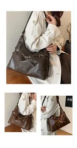 Detail of dark brown faux leather shoulder bag with gold buckle and pleated texture