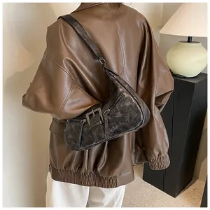 Gros plan sur le sac en cuir marron foncé au design vintage avec boucles métalliques rétro