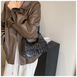 Détail de la texture cuir gris vintage et boucle argentée sur ce sac à main demi-lune