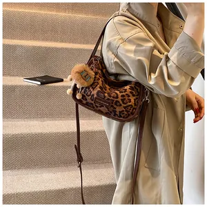 Détail du sac en daim léopard avec bandoulière marron et breloque lion en peluche