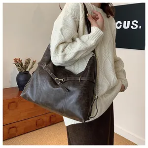 Detailed view of coffee brown vintage tote bag worn by model in a minimalist home setting
