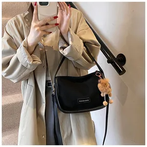Détail du sac en nylon noir avec breloque ours et écusson en cuir Fashion & Bags
