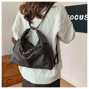 Rear view of model wearing a vintage dark brown leather backpack with gold hardware