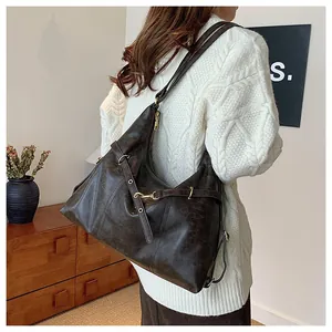 Macro view of dark brown vintage leather tote bag with gold buckle and textured finish