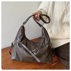 Detail of vintage brown hobo bag showing faux leather texture and gold hardware accents