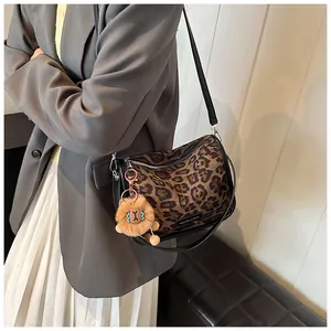 Détail du sac bandoulière léopard avec breloque lion en peluche et étiquette mode