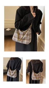 Détail du sac hobo vintage à carreaux marron et bleu avec chaîne dorée et cuir souple