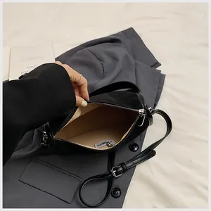 Vue intérieure du sac bandoulière en suède noir avec doublure kaki et fermeture éclair
