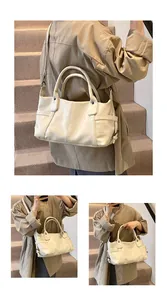 Detail of cream leather tote bag showing double handles and detachable shoulder strap
