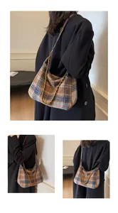 Détail du sac hobo à carreaux vintage avec chaîne dorée et lanière en cuir